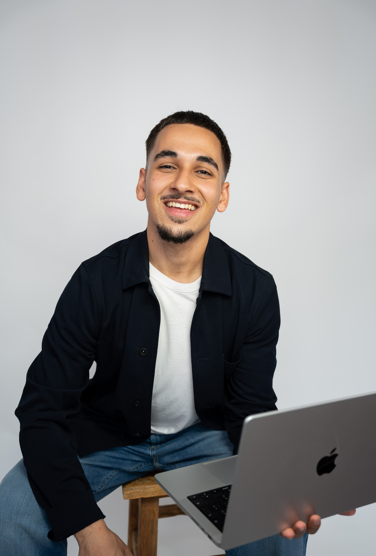 Mirza lacht met zijn laptop, 1-op-1 Franse les online via Zoom